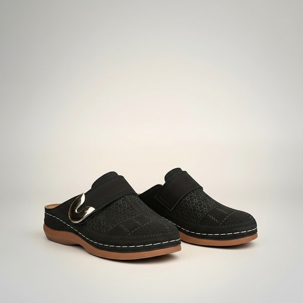 Black slip-on orthopedic slippers with metal buckle strap and perforated upper.