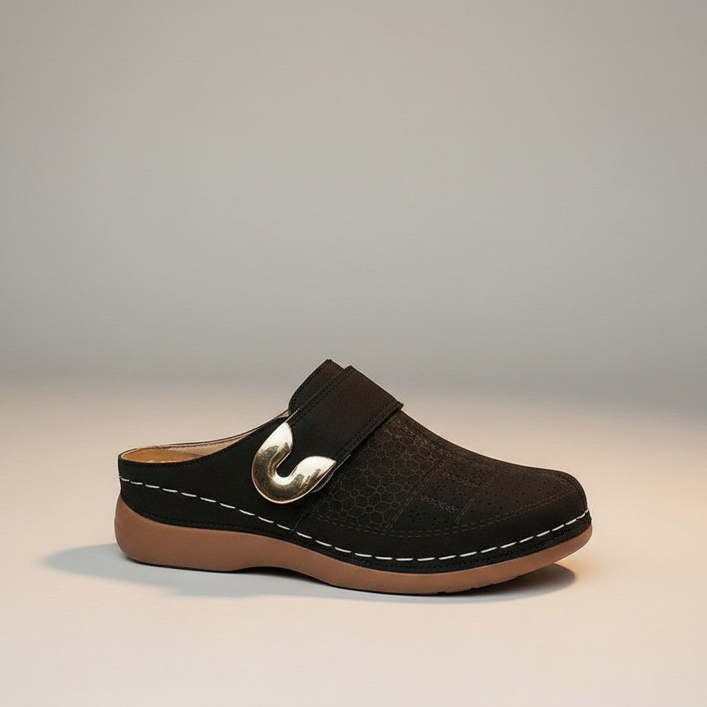 Black slip-on mules with metal buckle strap and stitched edge on low sole.