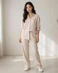 Cream striped button-up blouse with blue vertical lines, chest pocket, and rolled sleeves.