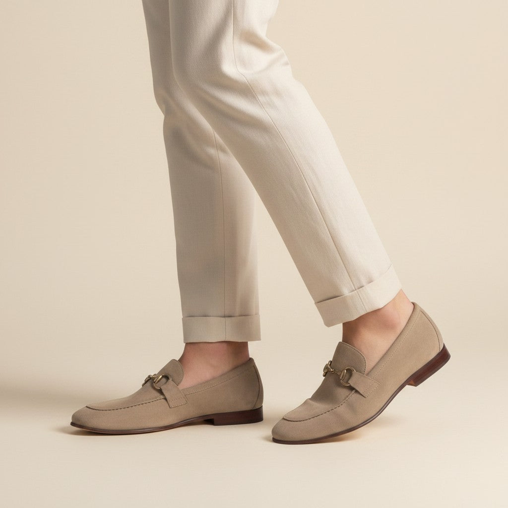Beige suede loafers with horsebit detail on feet, almond toe slip-on