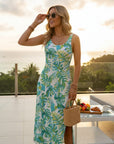 Teal and green tropical leaf print sleeveless sundress with fitted bodice.