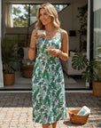 Green sleeveless sundress with white leaf print and scoop neck, fitted waist.