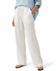 White wide-leg linen pants with elastic waist and drawstring, relaxed straight silhouette.