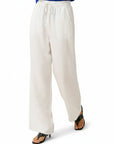 White wide-leg linen trousers with elastic waist and drawstring, long relaxed silhouette.