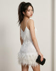 White sequin mini dress with spaghetti straps and feather fringe hem