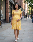 Yellow floral maternity dress with V-neck and flutter sleeves, front view