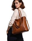 Cognac leather tote bag with long shoulder strap and front pocket detail