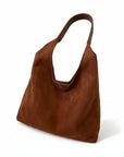 Brown suede shoulder bag with open top and short curved handle.